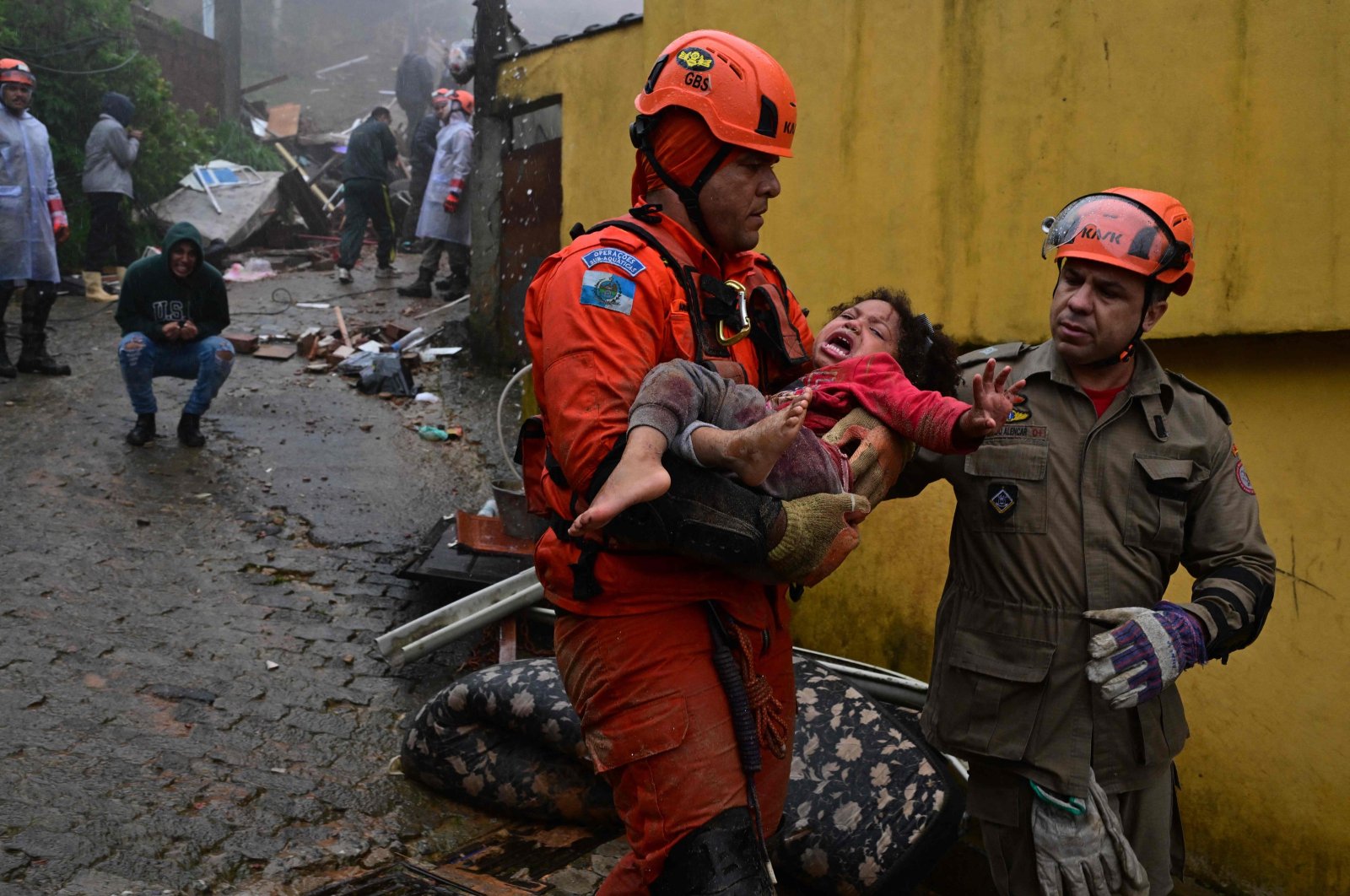 Brazilian emergency workers carry a girl, who was rescued after more than 12 hours under the rubble of her house destroyed by the heavy rains in Petropolis, Brazil, March 23, 2024. (AFP Photo)
