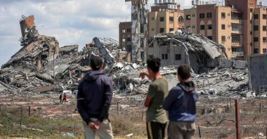 Youths watch from afar as people search the rubble of destroyed buildings in the Asra residential compound, Gaza Strip, Palestine, March 25, 2024. (AFP Photo)