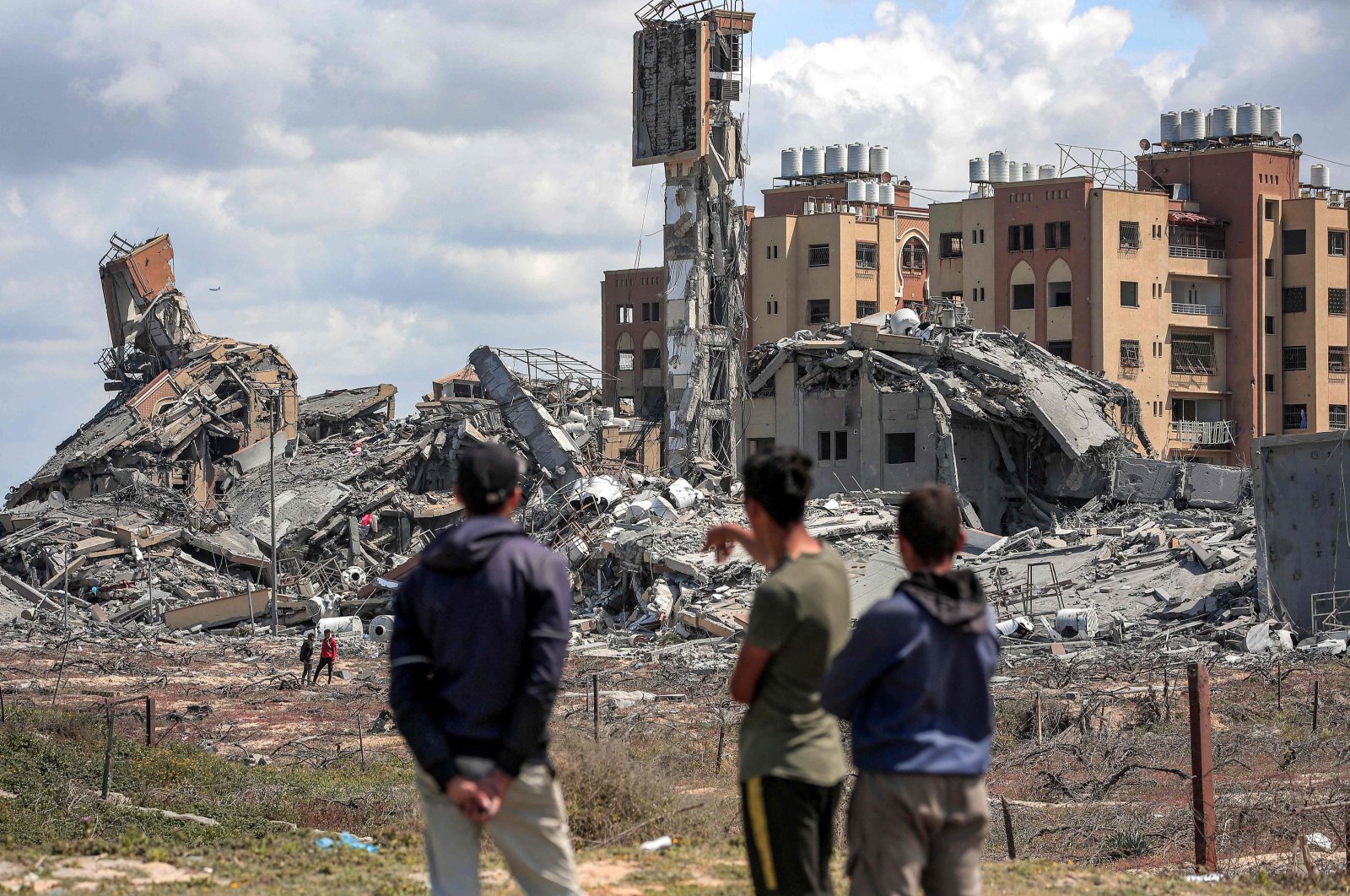 Youths watch from afar as people search the rubble of destroyed buildings in the Asra residential compound, Gaza Strip, Palestine, March 25, 2024. (AFP Photo)