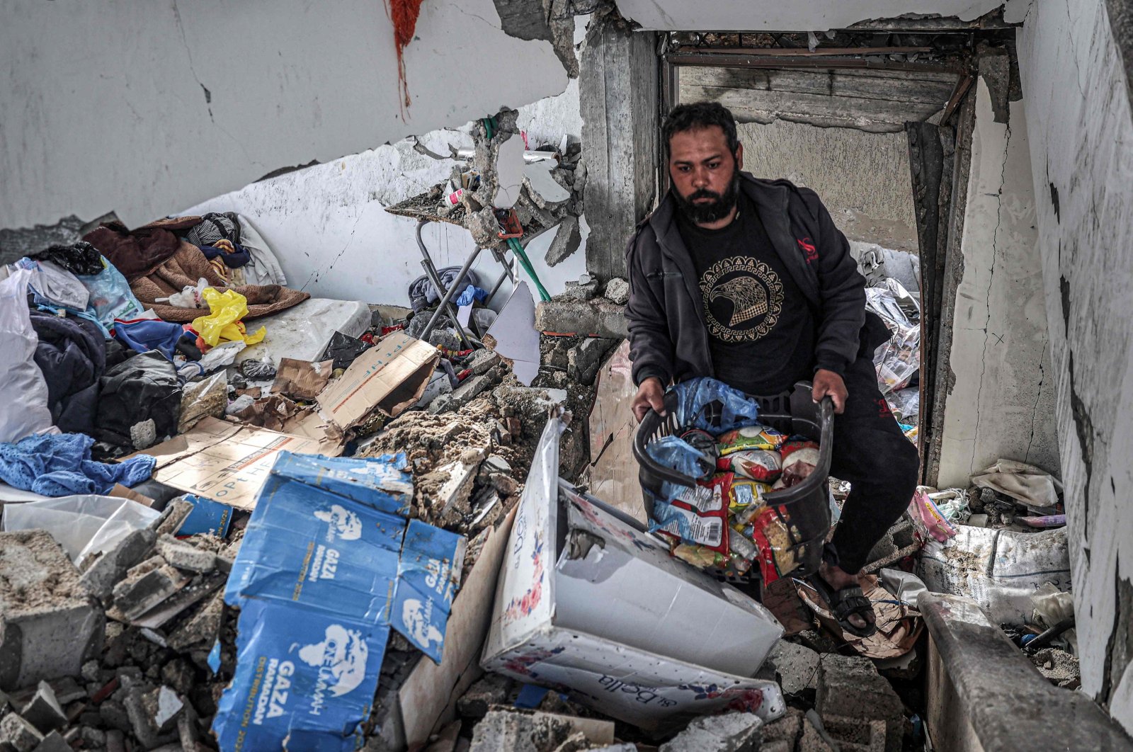A man salvages food packages from a building that was hit overnight by Israeli bombardment, in Rafah, southern Gaza Strip, Palestine, March 26, 2024. (AFP Photo)