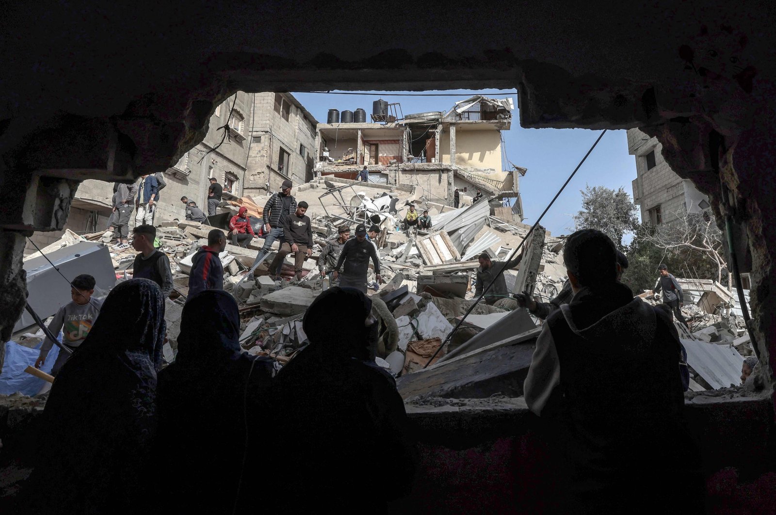 Palestinians check the rubble of buildings that were destroyed following overnight Israeli bombardment in Rafah, in the southern Gaza Strip, on March 27, 2024. (AFP Photo)