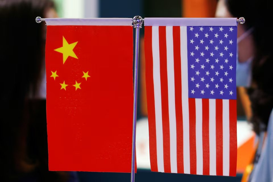 Staff members chat behind Chinese and U.S. flags displayed at the 2021 China International Fair for Trade in Services (CIFTIS) in Beijing, China Sept. 4, 2021. (Reuters Photo)