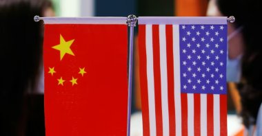 Staff members chat behind Chinese and U.S. flags displayed at the 2021 China International Fair for Trade in Services (CIFTIS) in Beijing, China Sept. 4, 2021. (Reuters Photo)