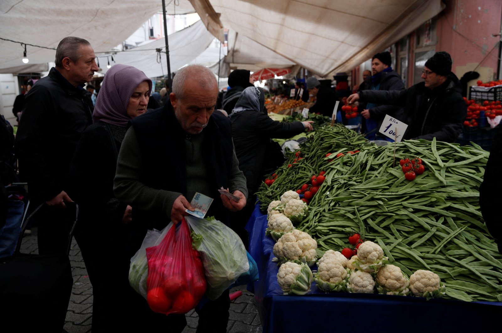 A man counts his money as he shops at a fresh market in Istanbul, Türkiye, March 6, 2024. (Reuters Photo)