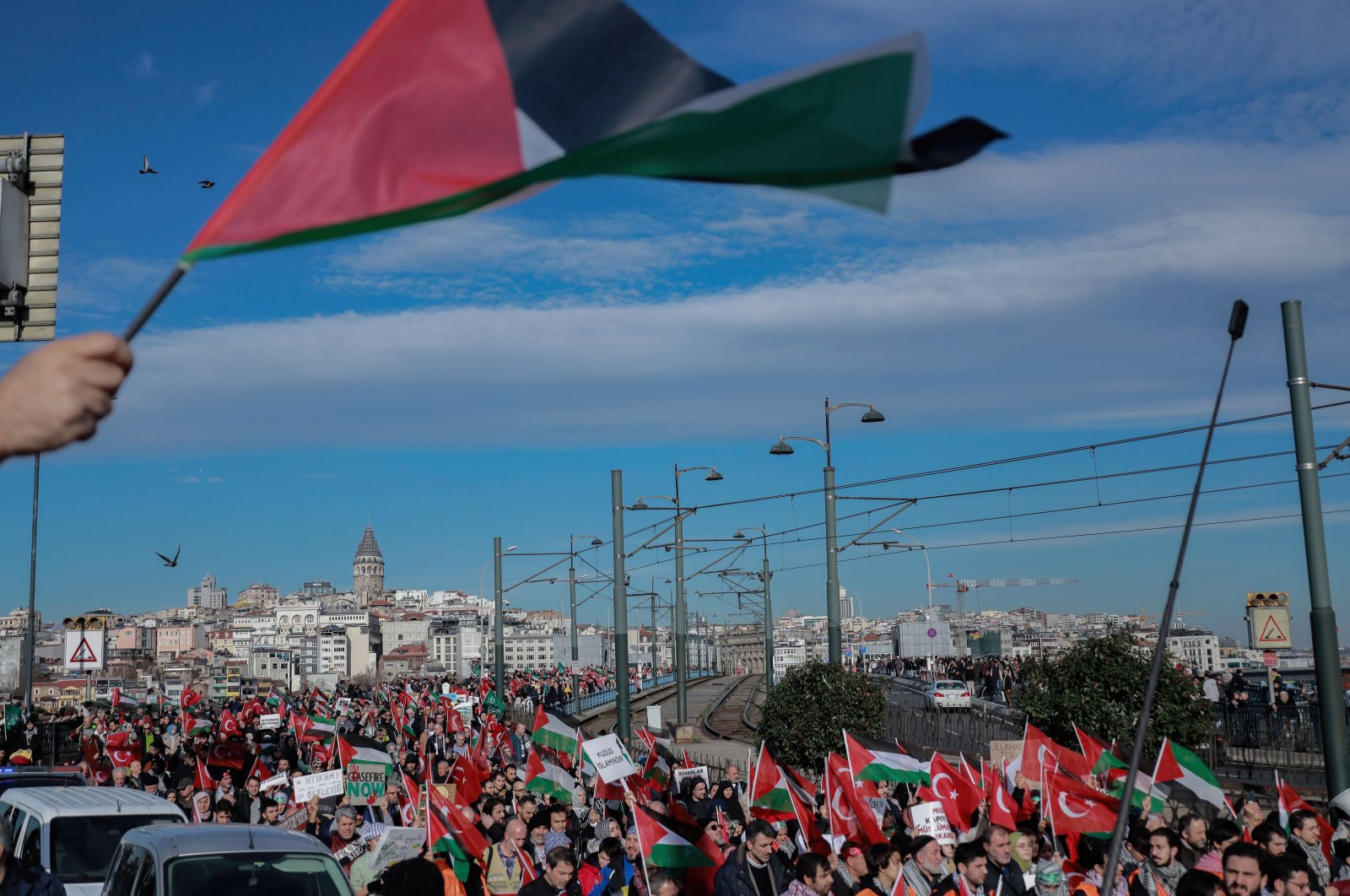 A group of Turks carry Palestinian and Turkish flags and banners in a protest march against Israeli attacks on Palestine on the Galata Bridge in Istanbul, Türkiye, Dec. 24, 2023. (Reuters Photo)