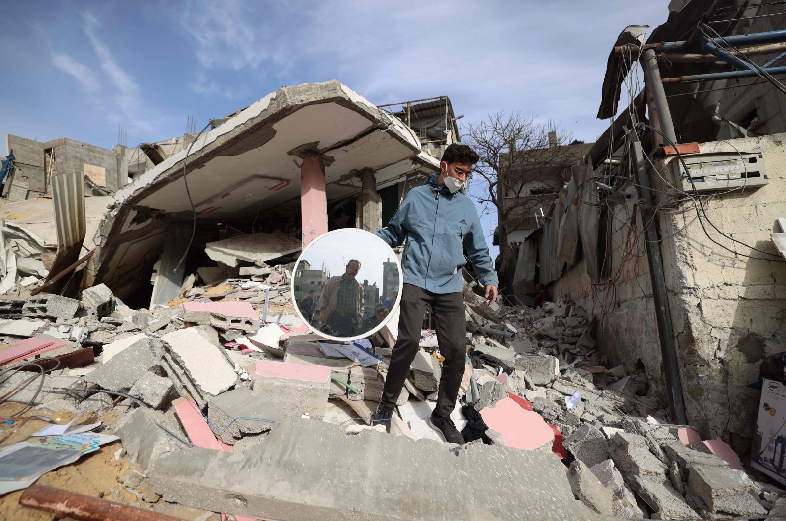 A Palestinian man carries a mirror recovered from debris following Israeli bombardment in Rafah, in the southern Gaza Strip, on March 27, 2024, amid the ongoing conflict between Israel and the Palestinian militant group Hamas. (Photo by MOHAMMED ABED / AFP)