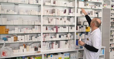A pharmacist is seen picking out some medicine boxes from a rack in a pharmacy, Konya, Türkiye, on March 29, 2024. (AA Photo)