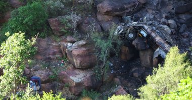 Police officers collect clothing items near the burnt remains of the bus that was taking Easter pilgrims from Botswana to Moria, Limpopo, South Africa, March 29, 2024. (Reuters Photo)