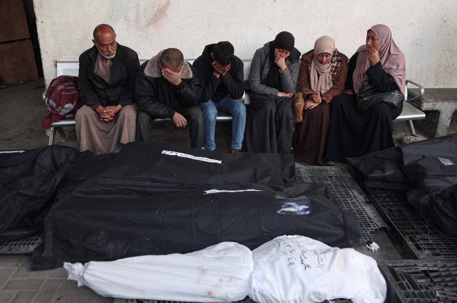 Palestinians mourn over the covered bodies of relatives, killed in overnight Israeli bombardment, at the al-Najjar hospital in Rafah in the southern Gaza Strip on March 25, 2024. (AFP Photo)