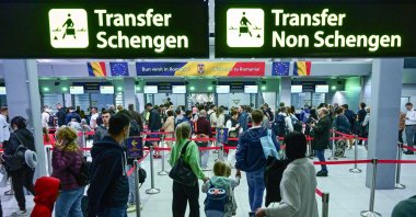 Travelers walk next to newly installed signs pointing to Schengen and non-Schengen areas minutes after midnight, just after Romania&#039;s official entry into the European area of free circulation at Otopeni&#039;s &quot;Henri Coanda&quot; international airport, Otopeni City, Romania, March 31, 2024. (AFP Photo)