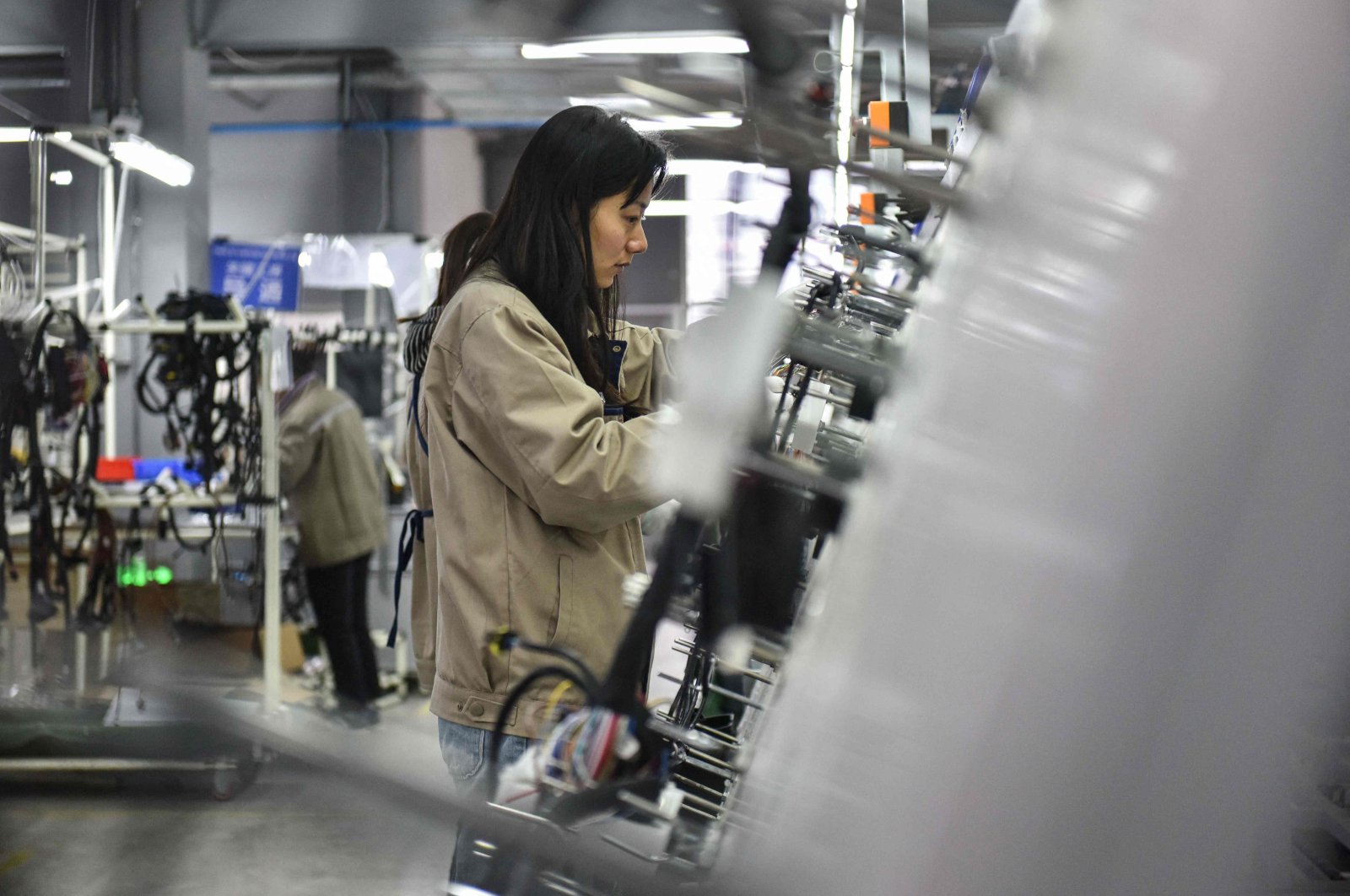 Employees work on a wire harness production line at a factory that supplies car accessories to the automotive market in Fuyang, in eastern China&#039;s Anhui province, on March 28, 2024. (AFP Photo)