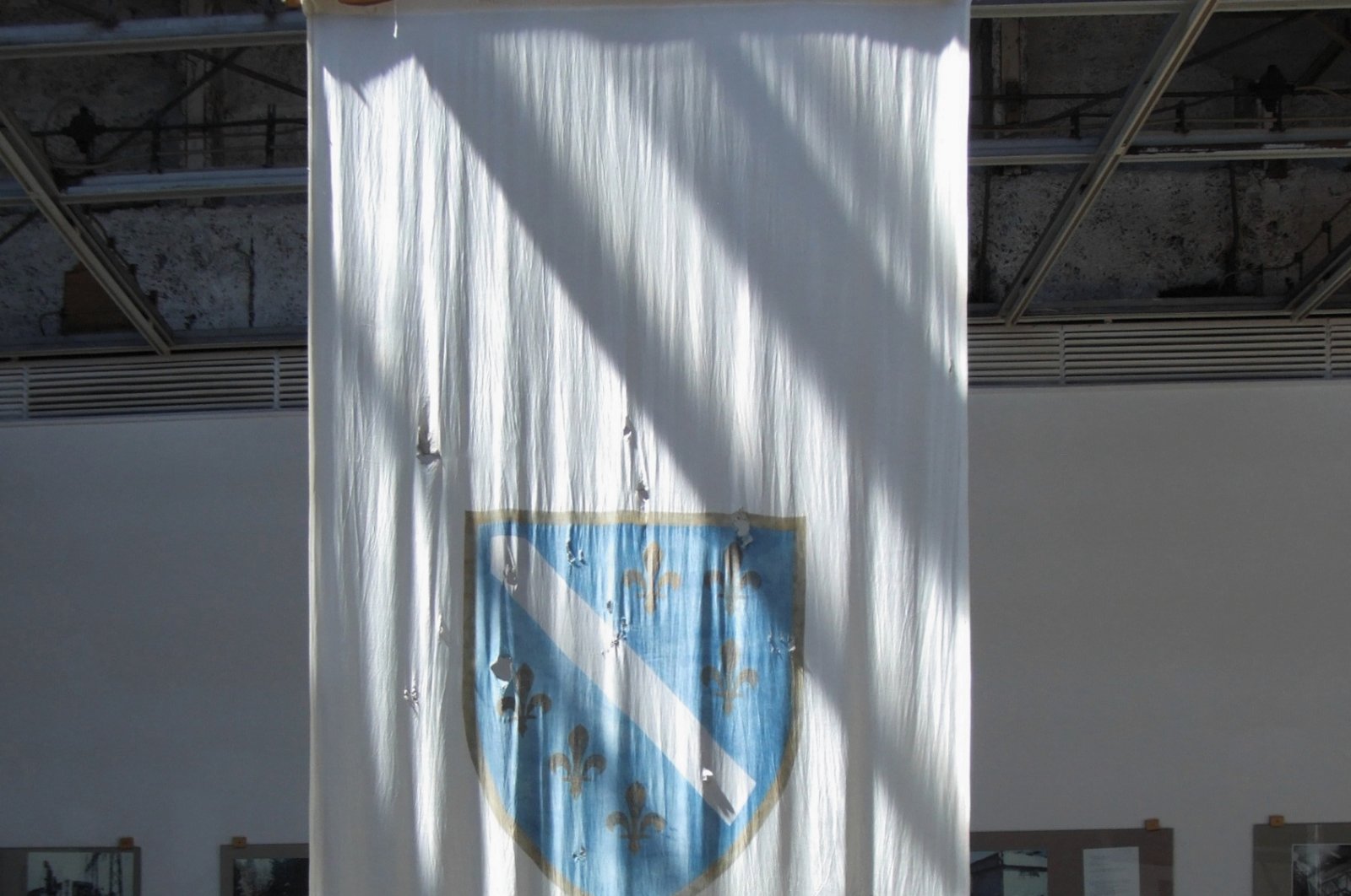 Now displayed in the History Museum, the old Bosnian flag bears the scars of shrapnel, serving as a poignant reminder of the nation&#039;s tumultuous past. (Wikipedia Photo)