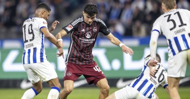 Nuremberg's Can Uzun (C) vies for the ball with Berlin's Jeremy Dudziak (L) and Jonjoe Kenny during the Bundesliga second division match, March 30, 2024. (AP Photo)