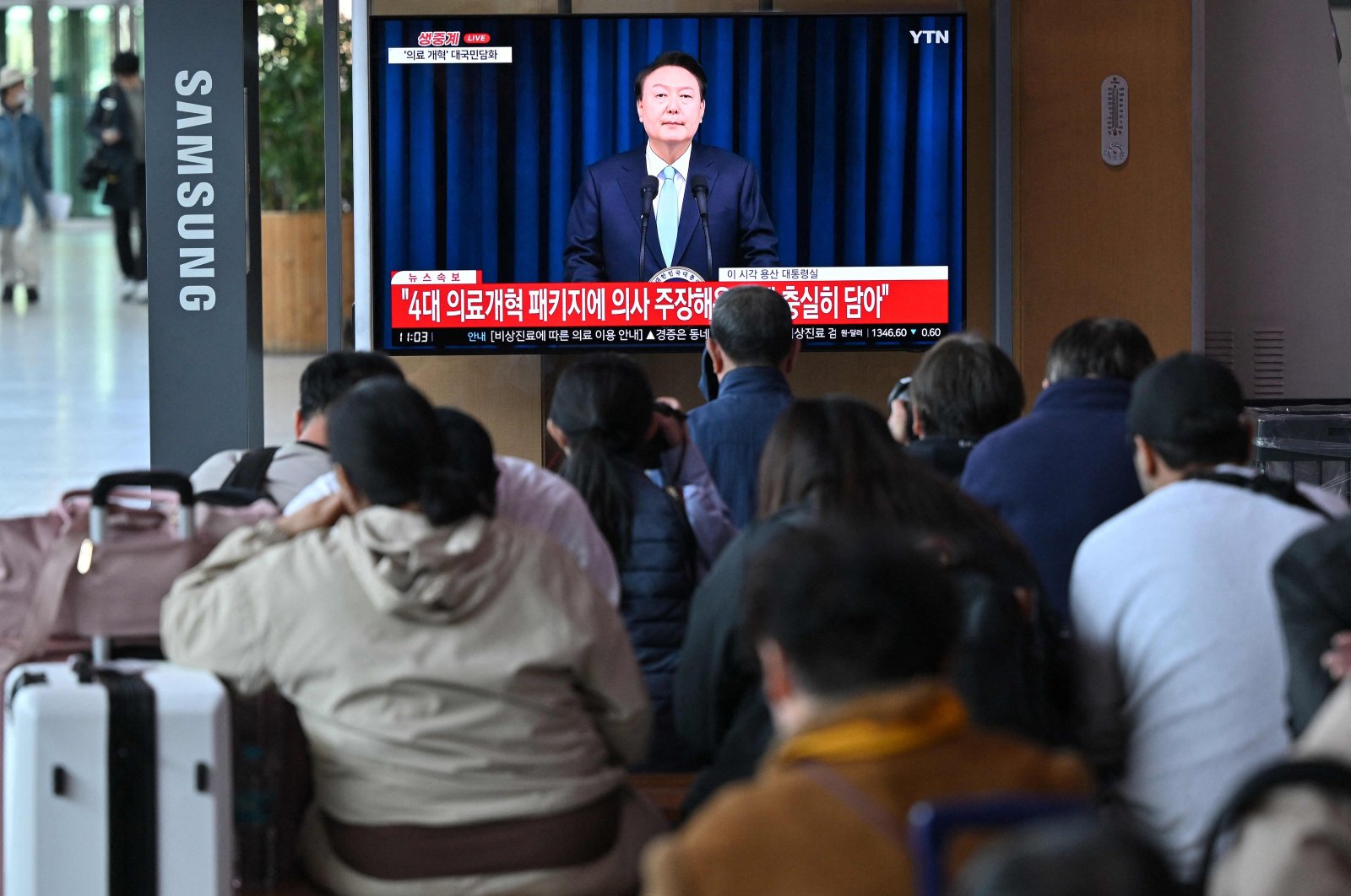 People watch a television news program broadcasting live footage of South Korean President Yoon Suk Yeol delivering a speech on his medical reform plans at a railway station in Seoul, South Korea, April 1, 2024. (AFP Photo)