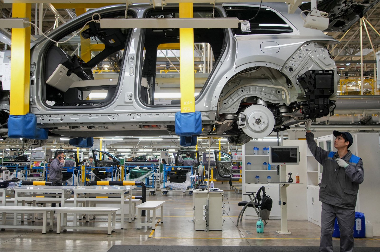 This photo shows employees working on a car assembly line at a factory of Chinese carmaker Li Auto in Changzhou, in eastern Jiangsu province, China,  March 27, 2024. (AFP Photo)