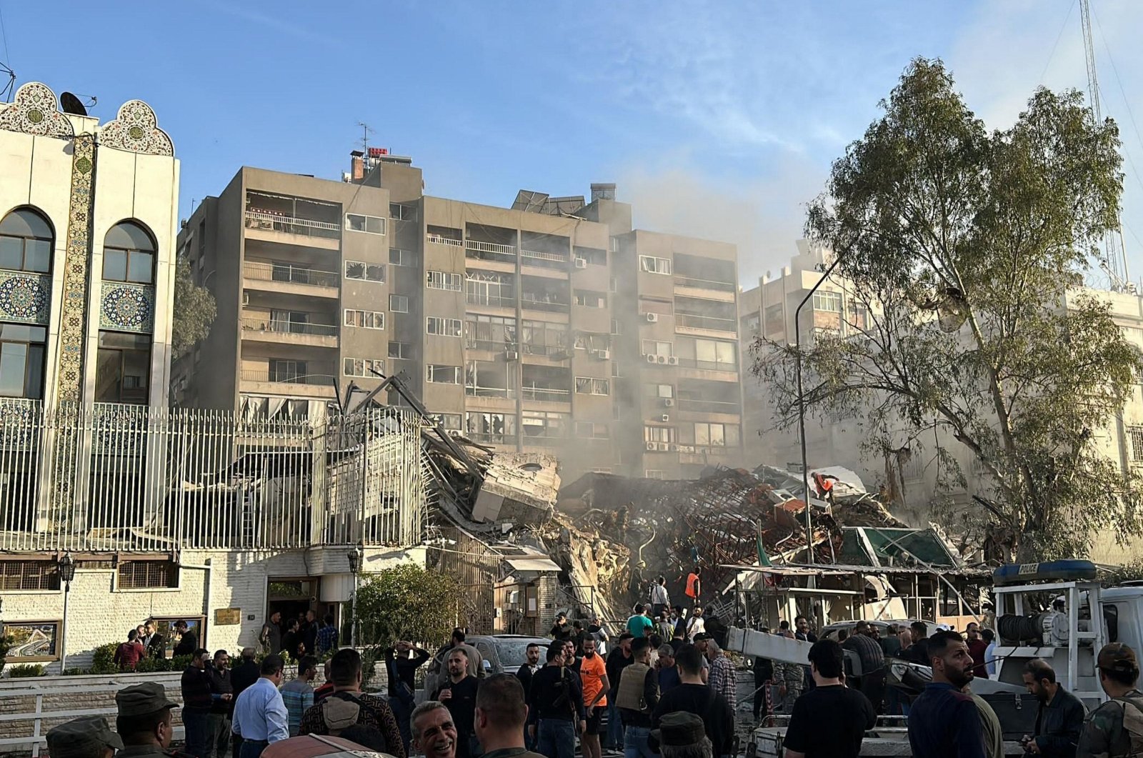 Emergency and security personnel gather at the site of strikes which hit a building adjacent to the Iranian embassy in Syria&amp;amp;#039;s capital Damascus, on April 1, 2024. (AFP Photo)