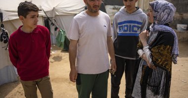 Heba al-Haddad (R) and her family, displaced from Gaza City, stand in a makeshift tent camp, Rafah, Gaza, Palestine, March 29, 2024. (AP Photo)