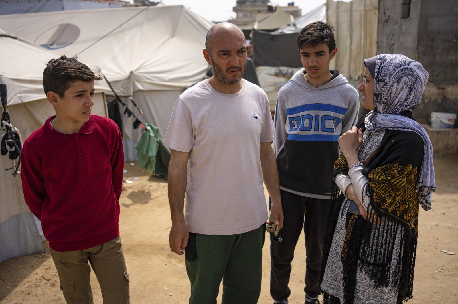 Heba al-Haddad (R) and her family, displaced from Gaza City, stand in a makeshift tent camp, Rafah, Gaza, Palestine, March 29, 2024. (AP Photo)