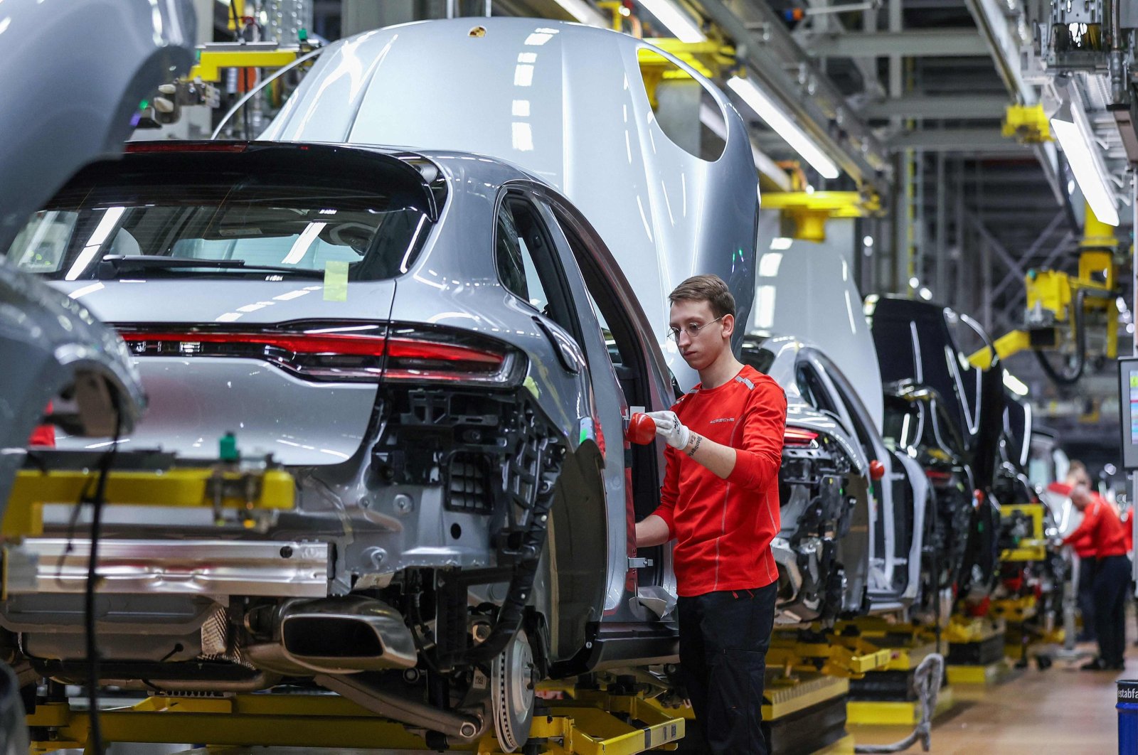 A worker assembles a Porsche Macan model on the production line of the Porsche plant, Leipzig, eastern Germany, March 11, 2024. (AFP Photo))