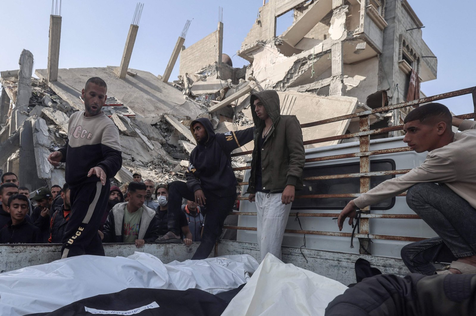 Palestinians gather around the bodies of victims before they are taken away following Israeli bombardment of a residential neighborhood in Rafah in the southern Gaza Strip, April 2, 2024. (AFP Photo)