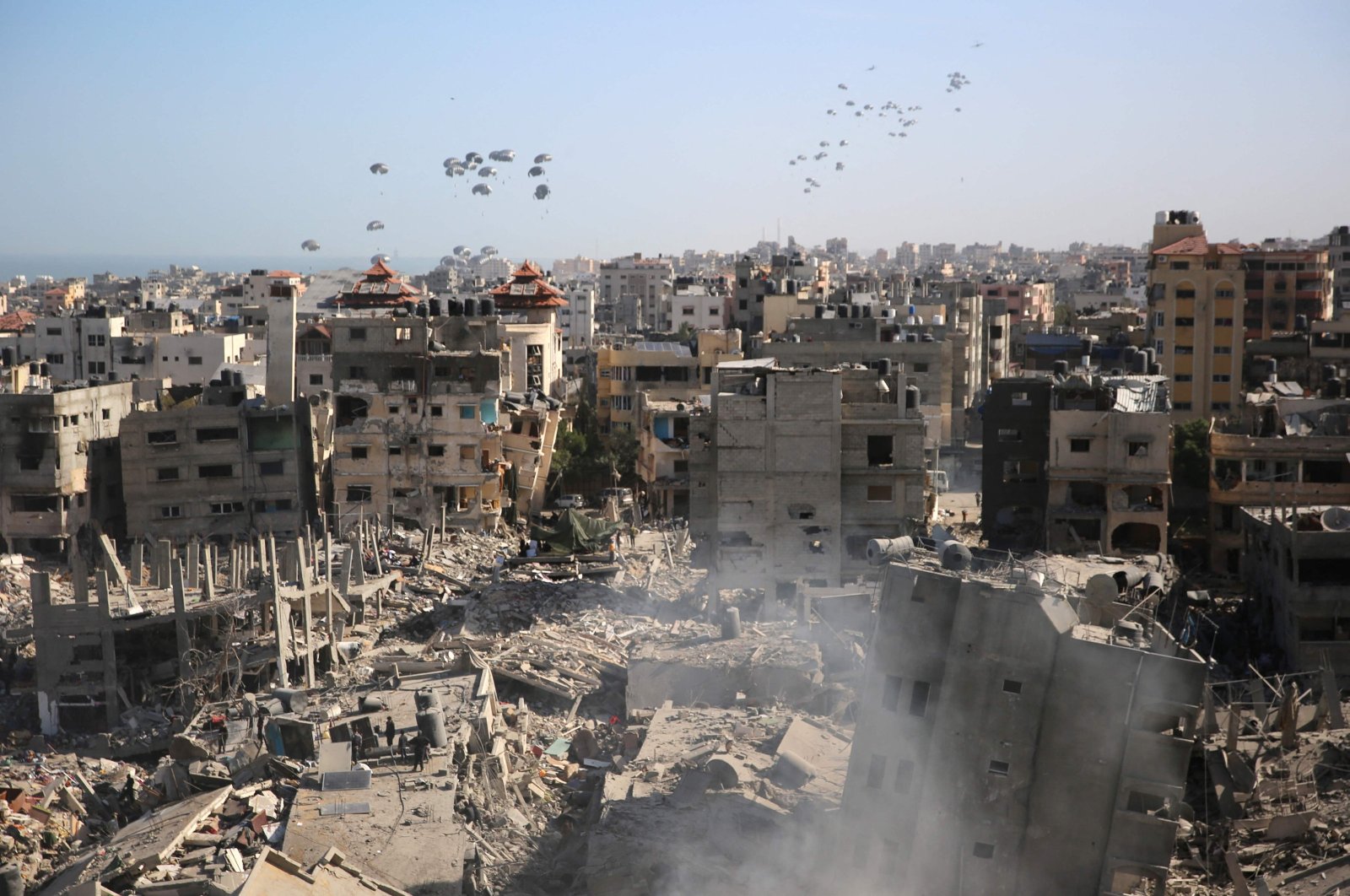 Humanitarian aid is dropped over the Gaza Strip as seen from Al-Shifa hospital after the Israeli military withdrew from the complex housing the hospital on April 1, 2024. (AFP Photo)