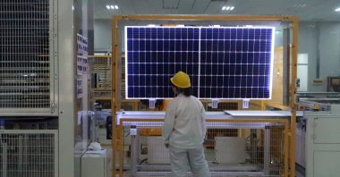 A worker conducts a quality check of a solar module product at a factory of a monocrystalline silicon solar equipment manufacturer LONGi Green Technology Co., in Xian, Shaanxi province, China, Dec. 10, 2019. (Reuters Photo)