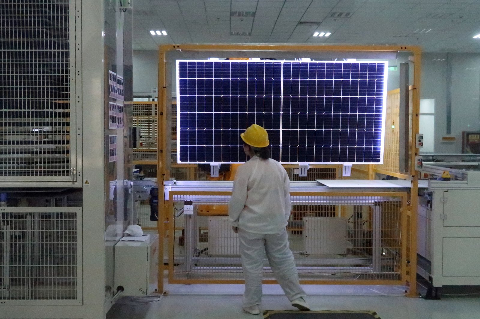 A worker conducts a quality check of a solar module product at a factory of a monocrystalline silicon solar equipment manufacturer LONGi Green Technology Co., in Xian, Shaanxi province, China, Dec. 10, 2019. (Reuters Photo)