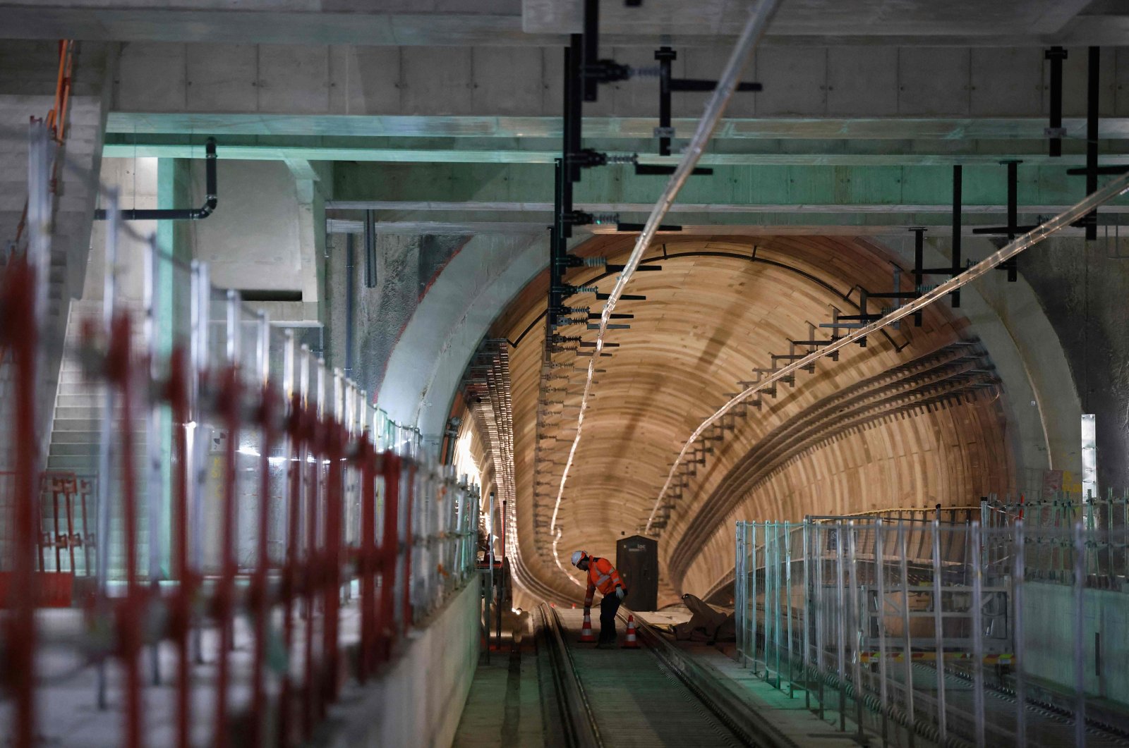 A worker places worksite cones in the metro tunnel prior to the last welding of the rails on the 15 South metro line of the new "Grand Paris Express", in the railway station of Clamart on April 3, 2024. (AFP Photo)