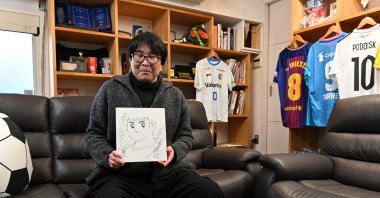 Japanese cartoonist and manga artist Yoichi Takahashi, best known for his work "Captain Tsubasa," displays his autograph with the painting of the main character following an interview at his workplace in Tokyo, Japan, Jan. 30, 2023. (AFP Photo)