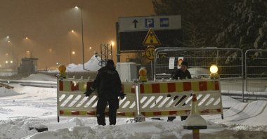 A Finnish border guard removes fences at the closed Vaalimaa border checkpoint between Finland and Russia, Virolahti, Finland, Dec. 13, 2023. (AP File Photo)