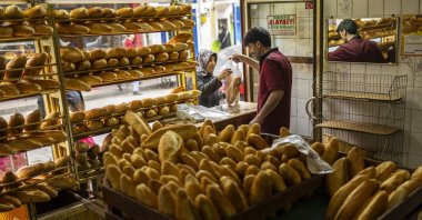 A woman buys bread in a local bakery in the Balat neighborhood of Istanbul, Türkiye, March 19, 2024. (AP Photo)