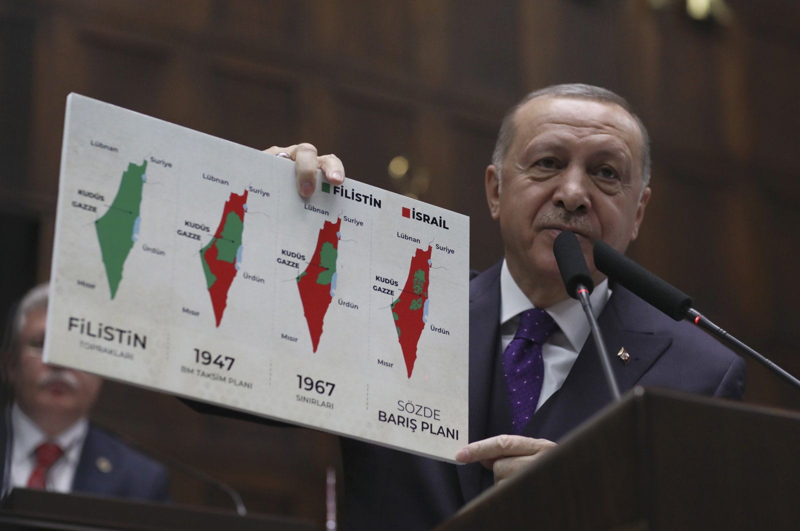 President Recep Tayyip Erdoğan holds up a placard with a series of maps of historical Palestine during a speech at the Parliament in Ankara, Türkiye, Feb. 5, 2020. (AP Photo)