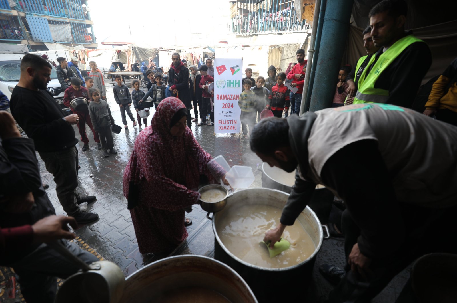 Humanitarian aid workers distribute food sent by the Turkish aid agency IHH in Gaza, March 14, 2024. (IHA Photo)