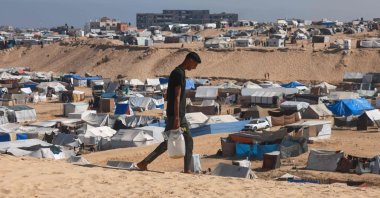 A Palestinian man ferries water at a makeshift camp for displaced people in Rafah in the southern Gaza Strip, Palestine, April 4, 2024. (AFP Photo)