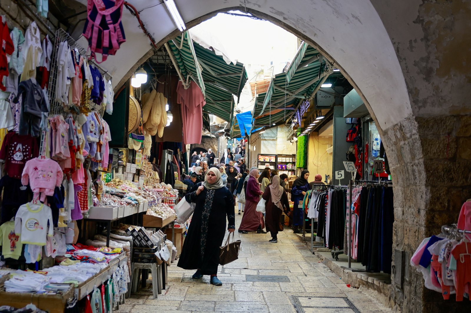 People walk near shops as Palestinians prepare for the upcoming holiday of Eid al-Fitr marking the end of Ramadan, in Jerusalem&#039;s Old City, April 8, 2024. (Reuters Photo)