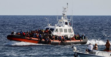 An Italian Coast Guard vessel carrying migrants rescued at sea passes near a tourist boat, Lampedusa, Italy, Sept. 18, 2023. (Reuters Photo)