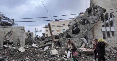Palestinians wade in rainwater as they walk past a destroyed mosque on the first day of the Eid al-Fitr festival marking the end of the holy month of Ramadan, Deir el-Balah, Gaza Strip, Palestine, April 10, 2024. (AFP Photo)
