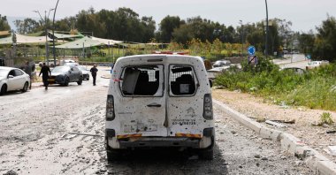 A damaged car sits amid debris on a road near a building hit by a Hezbollah rocket in Kiryat Shmona in northern Israel near the Lebanon border, March 27, 2024. (AFP File Photo)