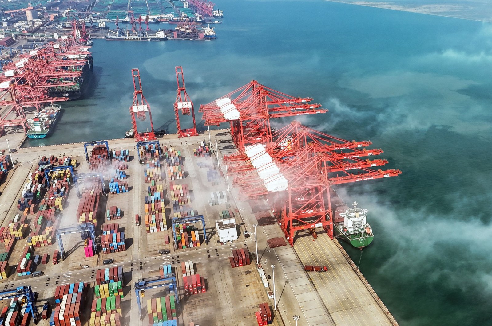 An aerial view shows gantry cranes and shipping containers at a port in Lianyungang, in eastern China&#039;s Jiangsu province, April 12, 2024. (AFP Photo)