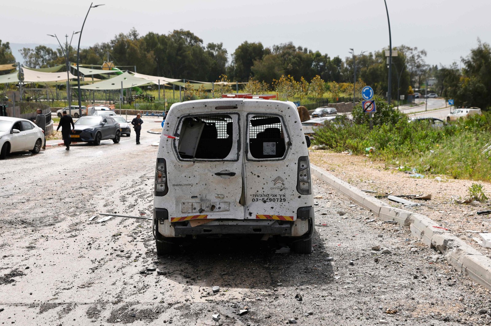 A damaged car sits amid debris on a road near a building hit by a Hezbollah rocket in Kiryat Shmona in northern Israel near the Lebanon border, March 27, 2024. (AFP File Photo)