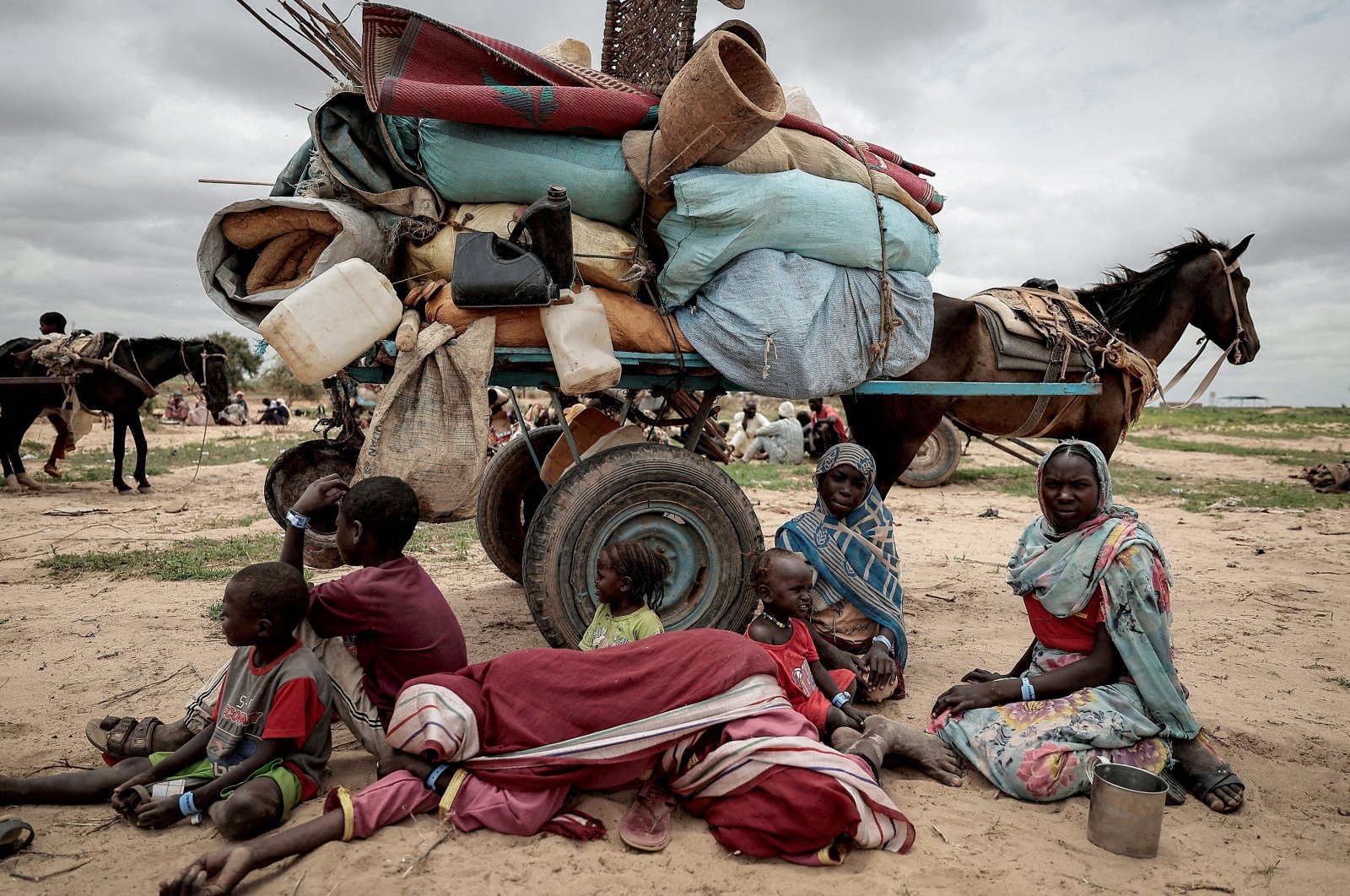 A Sudanese family who fled the conflict in Murnei in Sudan&#039;s Darfur region sit beside their belongings while waiting to be registered by UNHCR upon crossing the border between Sudan and Chad, Adre, Chad, July 26, 2023. (Reuters Photo)