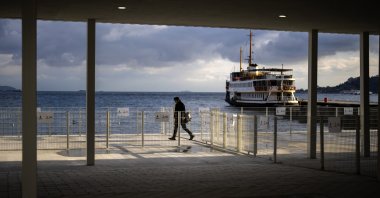 A man walks along a promenade next to the Bosporus at Kabataş ferry terminal in Istanbul, Türkiye, March 22, 2024. (AP Photo)
