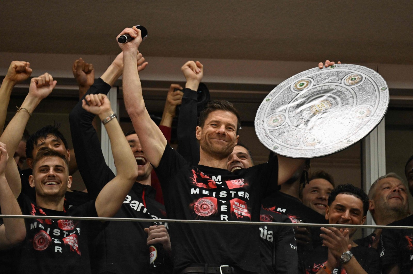 Bayer Leverkusen&#039;s Xabi Alonso celebrates with a mock-up of the Bundesliga trophy with his players after the German first division Bundesliga football match against Werder Bremen, Leverkusen, Germany, April 14, 2024. (AFP Photo)