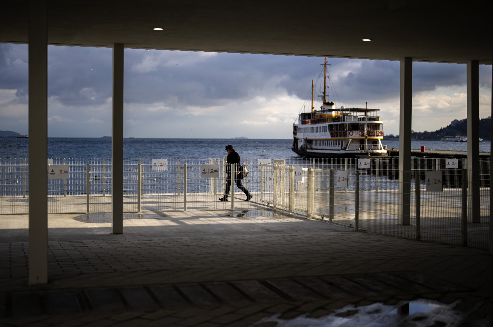 A man walks along a promenade next to the Bosporus at Kabataş ferry terminal in Istanbul, Türkiye, March 22, 2024. (AP Photo)