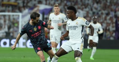 Real Madrid's Vinicius Jr. (R) in action against Manchester City's Bernardo Silva (L) during the UEFA Champions League quarterfinals first leg match, Madrid, Spain, April 9, 2024. (EPA Photo)