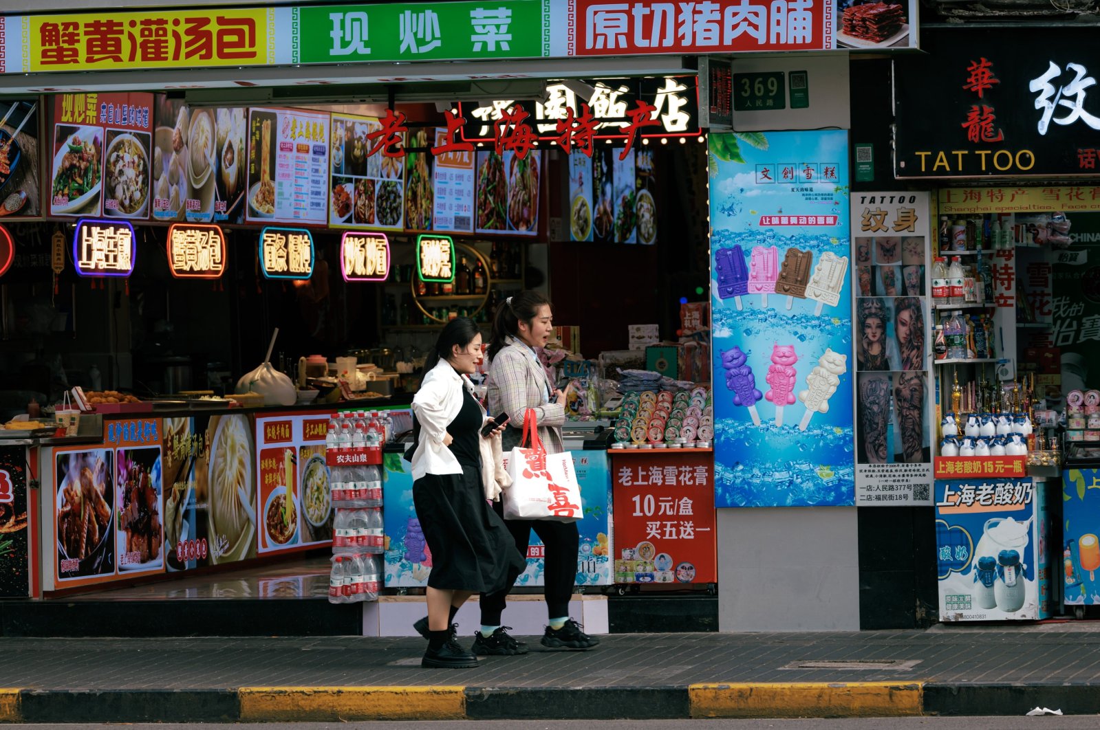 People walk past restaurants on a street in Shanghai, China, April 15, 2024. (EPA Photo)