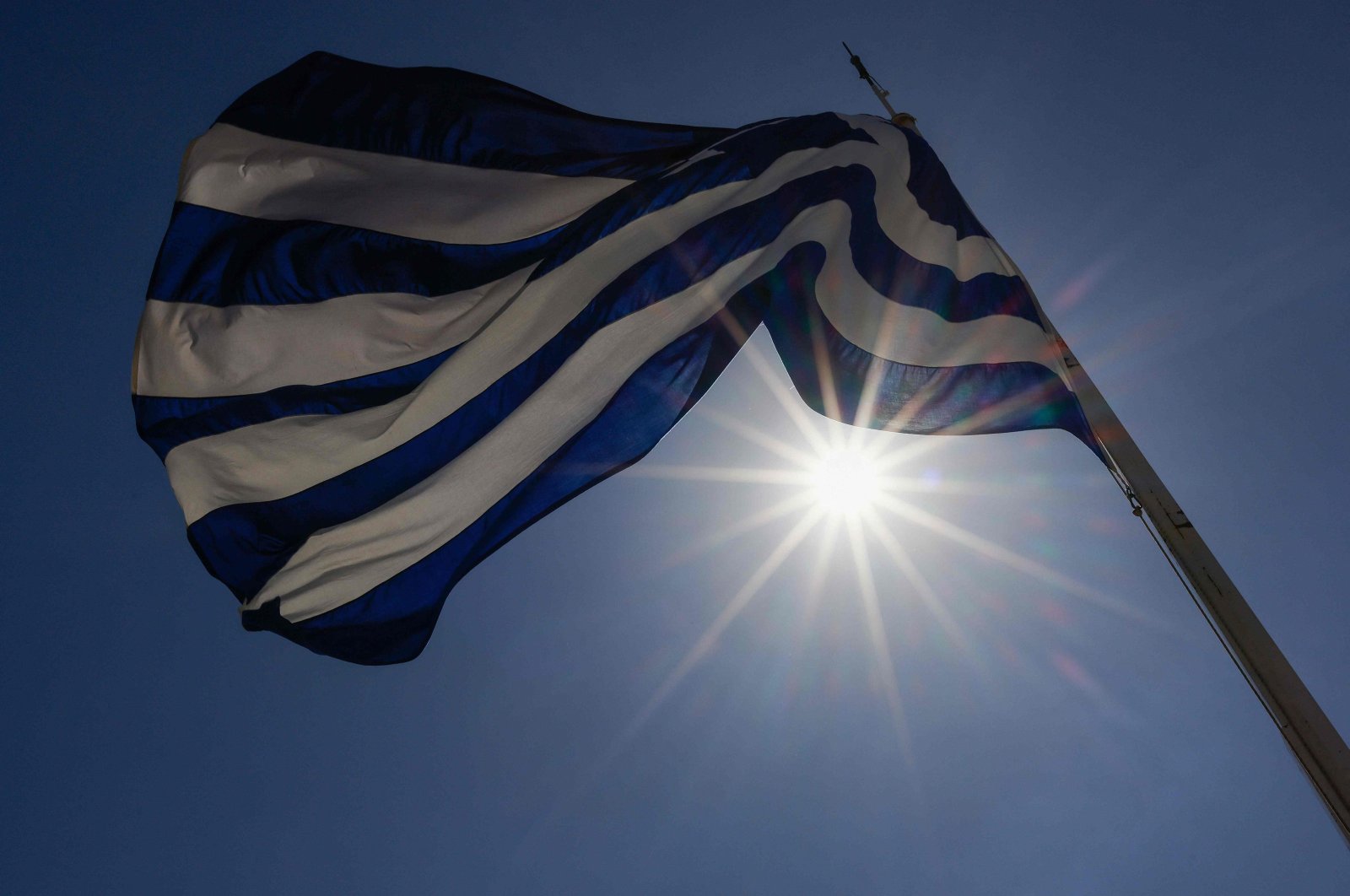 A Greek flag flutters in the breeze as the sun shines at the Acropolis archaeological site in Athens, Greece, April 5, 2024. (AFP Photo)