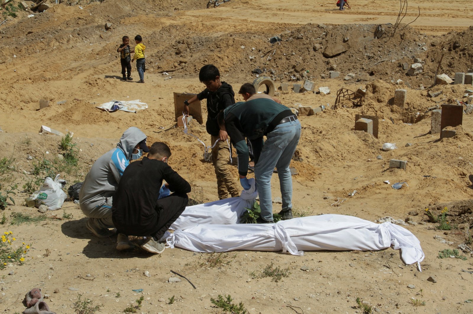 Palestinians cover a body, which was buried in a mass grave, amid the ongoing conflict between Israel and Hamas, northern Gaza Strip, Palestine, April 15, 2024. (Reuters Photo)