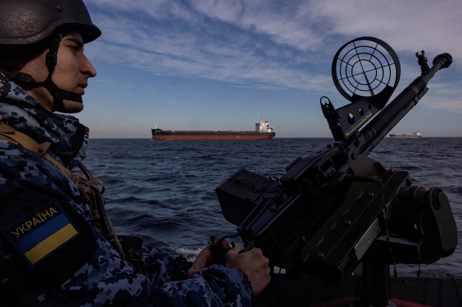 A member of Ukraine&#039;s coast guard mans a gun on a patrol boat as a cargo ship passes by in the Black Sea, amid Russia’s attack on Ukraine, Feb. 7, 2024. (Reuters Photo)
