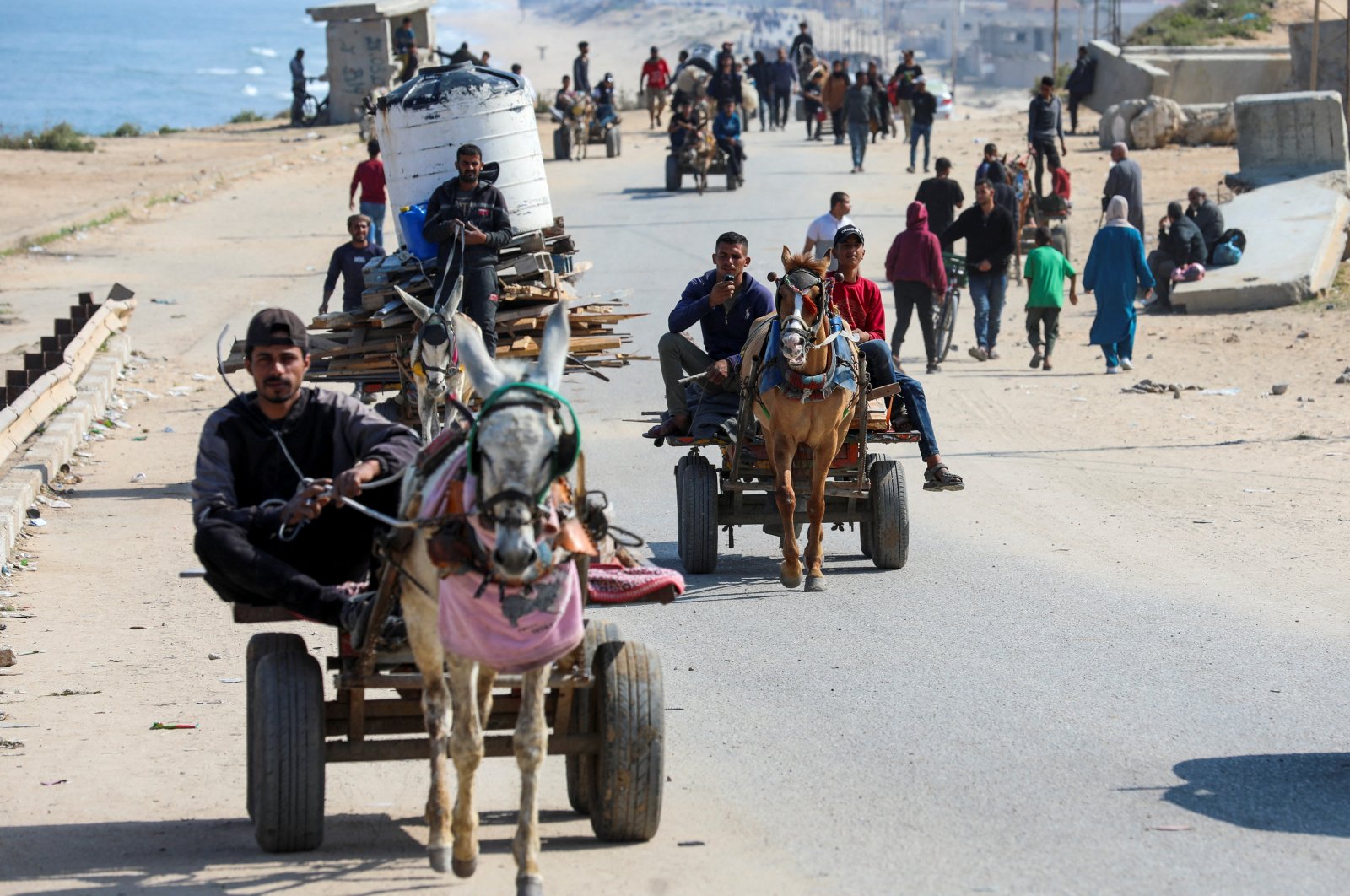 People ride animal-drawn carts as Palestinians, who were displaced by Israel&#039;s military offensive on south Gaza, make their way attempting to return to their homes in north Gaza through an Israeli checkpoint, Gaza Strip, Palestine, April 15, 2024. (Reuters Photo)